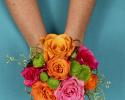This fun and colorful hand held bouquet features orange, pink & green flowers with fun accents of wire.