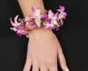 This unique floral bracelet features beautiful flowers with accents of pearls. This is definitely a creative take on a corsage.